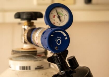 Detailed view of an oxygen tank with a pressure gauge, showcasing medical equipment usage.