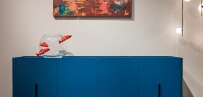 aquarium stand with fish tank — Modern blue cupboard with glass aquarium decorated with fish placed at white wall with creative picture in modern room with glowing lamps