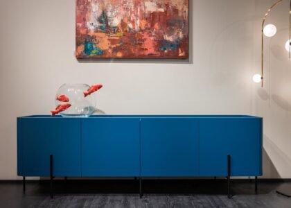 aquarium stand with fish tank — Modern blue cupboard with glass aquarium decorated with fish placed at white wall with creative picture in modern room with glowing lamps