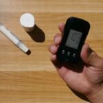 A hand holding a digital pH meter alongside a manual pH testing kit, illustrating the difference between the two types.
