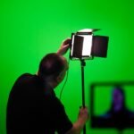 A person adjusting a studio light, illustrating how to manage aquarium light intensity.