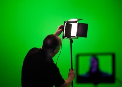 A person adjusting a studio light, illustrating how to manage aquarium light intensity.