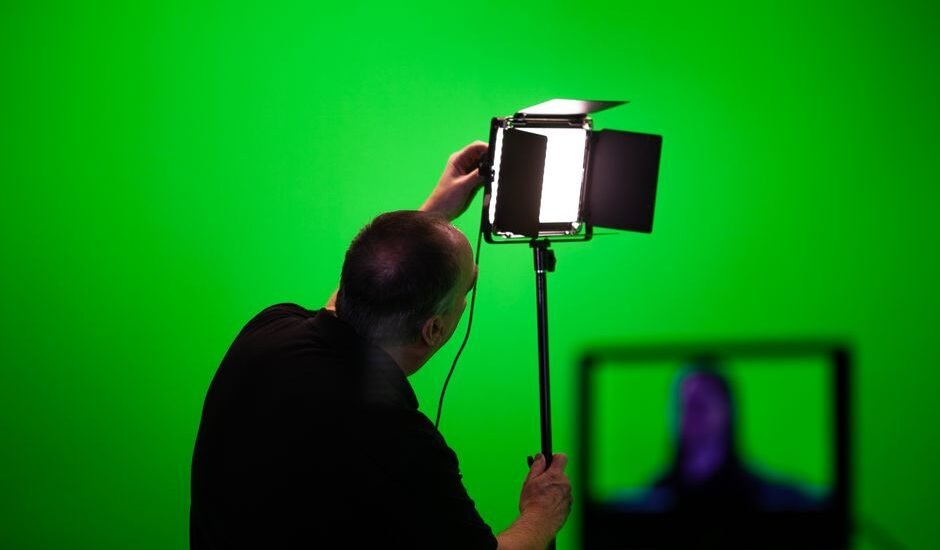A person adjusting a studio light, illustrating how to manage aquarium light intensity.