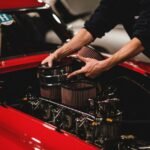 A person installing components in a car engine, illustrating the setup process for a double sponge filter.