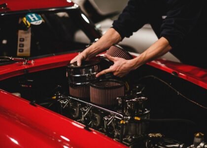 A person installing components in a car engine, illustrating the setup process for a double sponge filter.