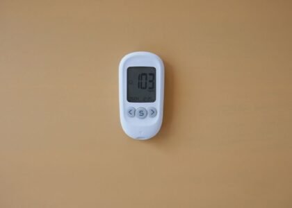 A digital water hardness tester showing a reading of 103 ppm, relevant for aquarium care.