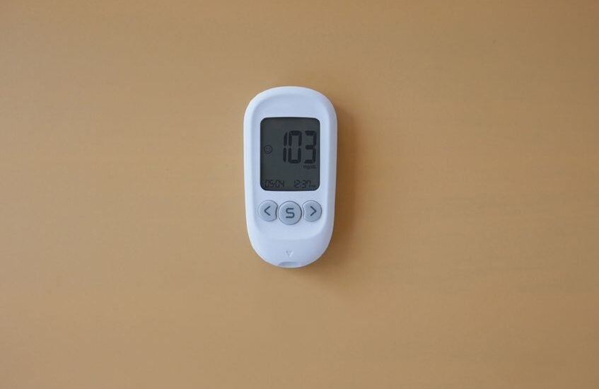 A digital water hardness tester showing a reading of 103 ppm, relevant for aquarium care.