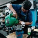 A person pouring water into a canister filter, illustrating how to prime a canister filter.