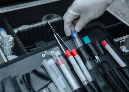 A hand in a glove holds a test tube from a water test kit, relevant to aquarium water test kit accuracy.